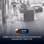 Toldo cai na cabeça de um homem em calçada de Cabo Frio